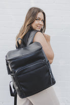 back pose woman carrying a black leather nappy backpack from Tottie