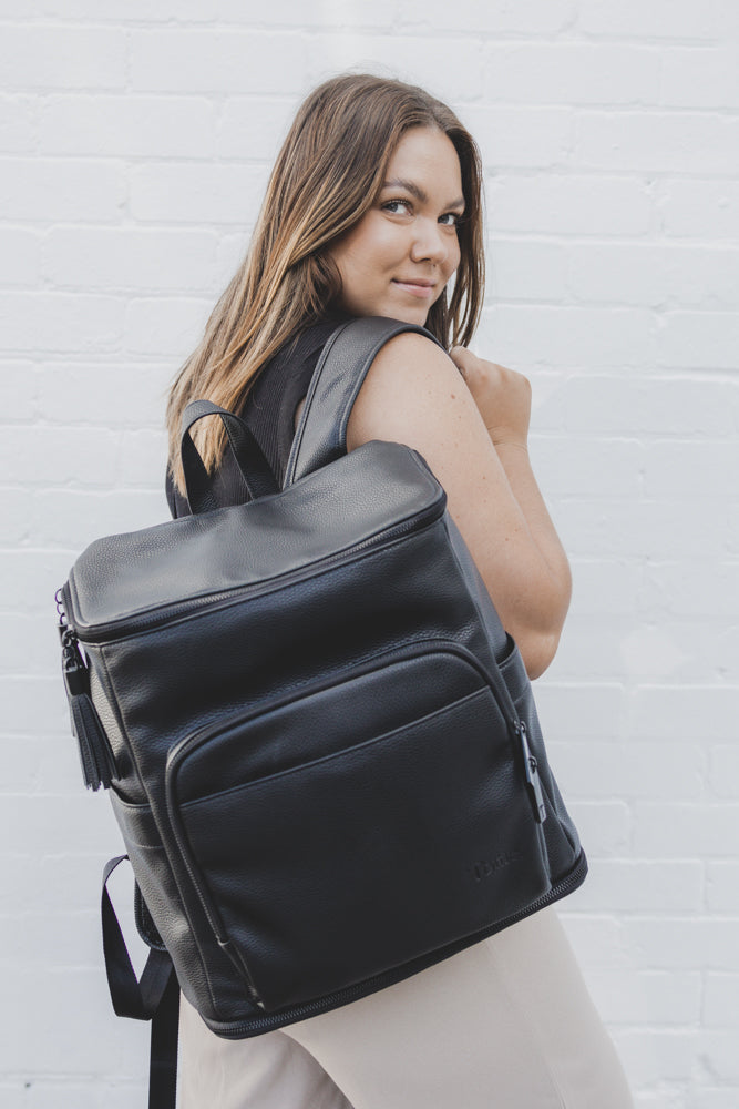 back pose woman carrying a black leather nappy backpack from Tottie