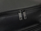 Close-up of the two black zippers on a black leather nappy backpack.