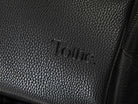 Close-up of the Tottie logo on a black leather nappy backpack