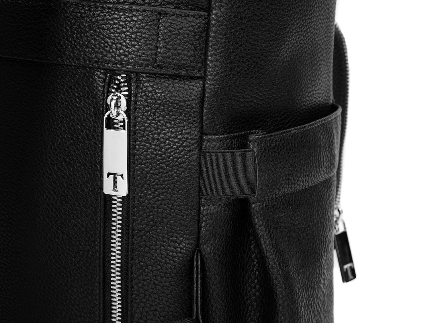 Close-up view of a silver zipper featuring the Tottie logo on a black leather nappy backpack with a silver zipper