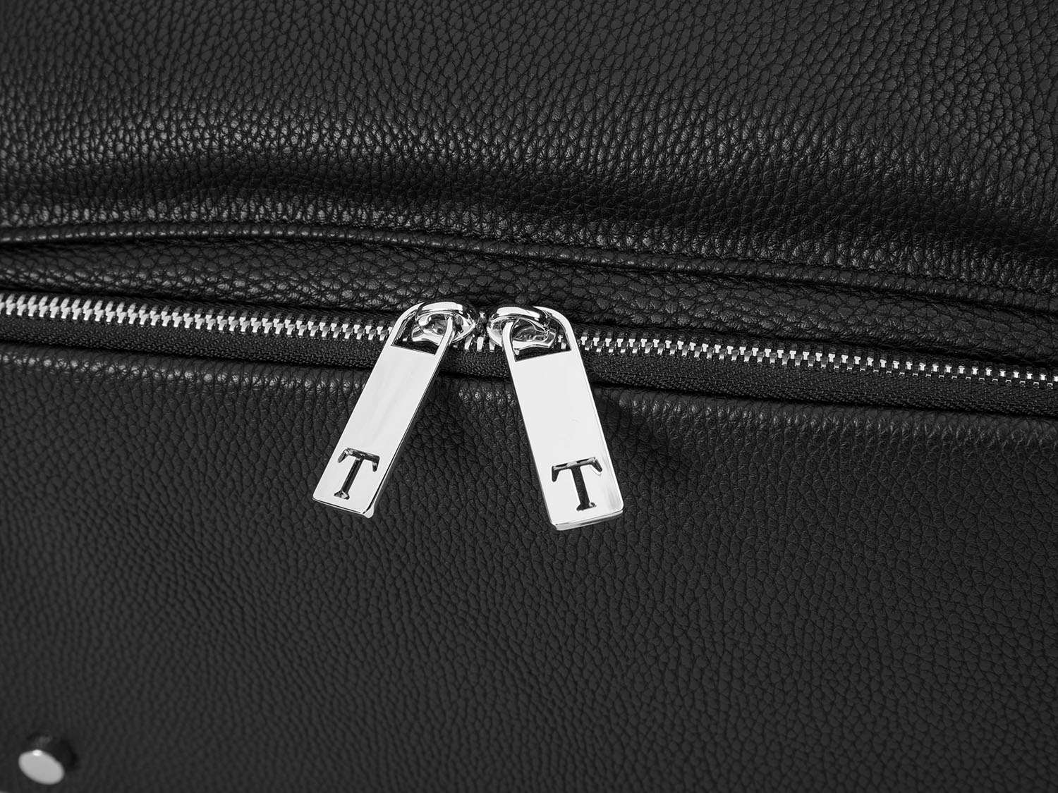 Close-up view of two silver zippers on a black leather nappy backpack from Tottie
