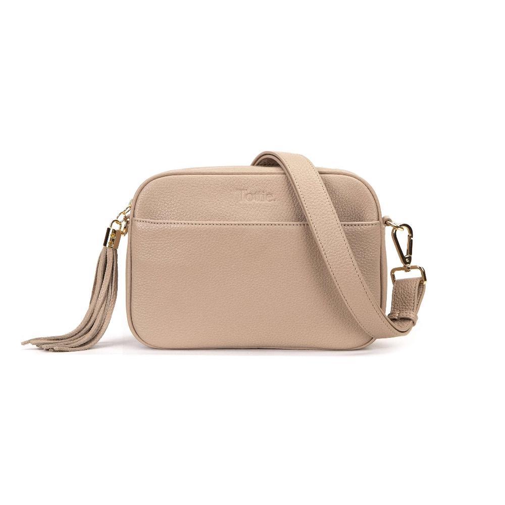 Stone-colored leather crossbody bag with gold-toned hardware. The bag features a chain strap, a tassel, and the brand name "Tottie" embossed on the front.