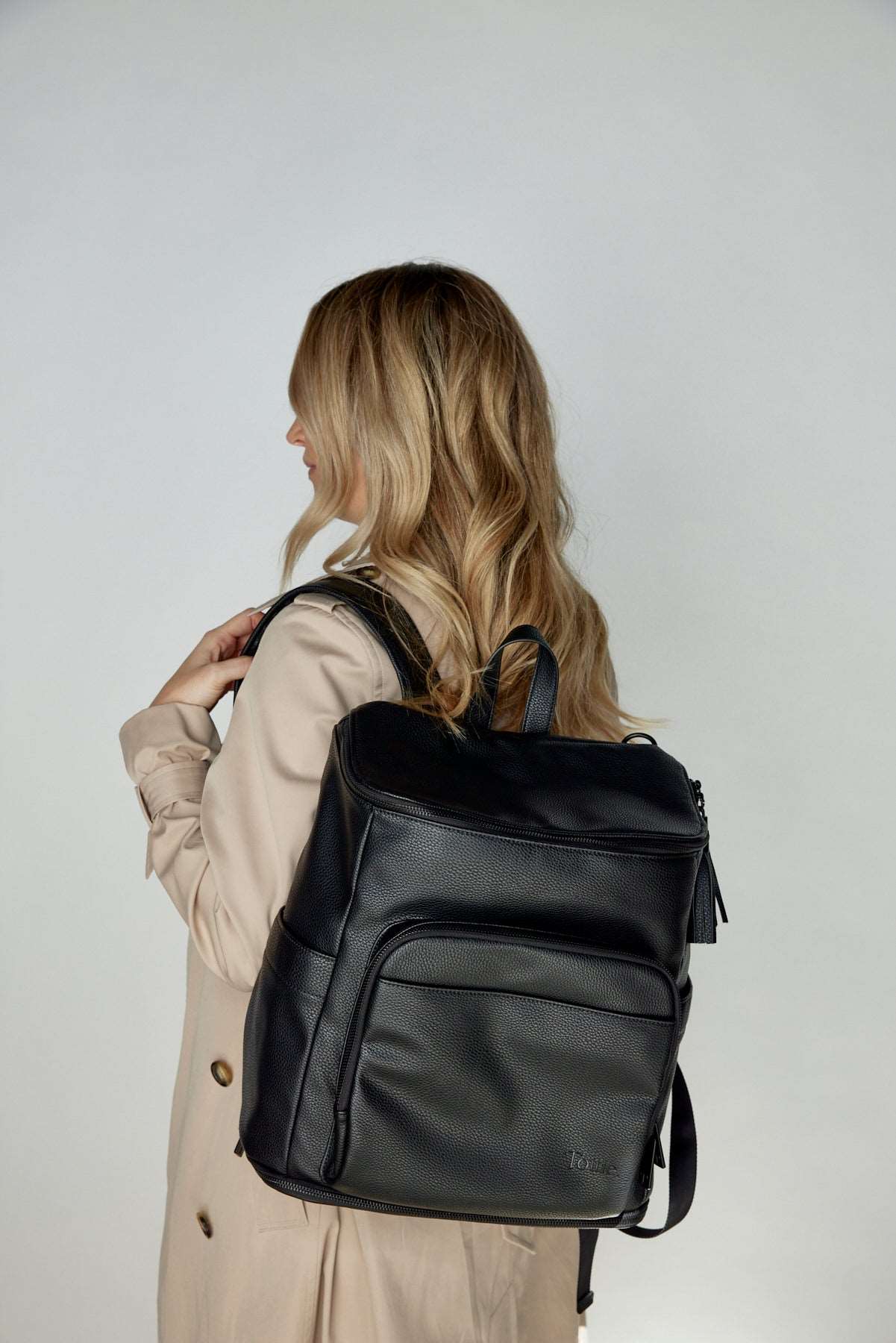 Woman facing away, wearing a black nappy backpack with a black zipper from Tottie.