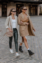 two women walking on the street carrying a bestie crossbody bag each